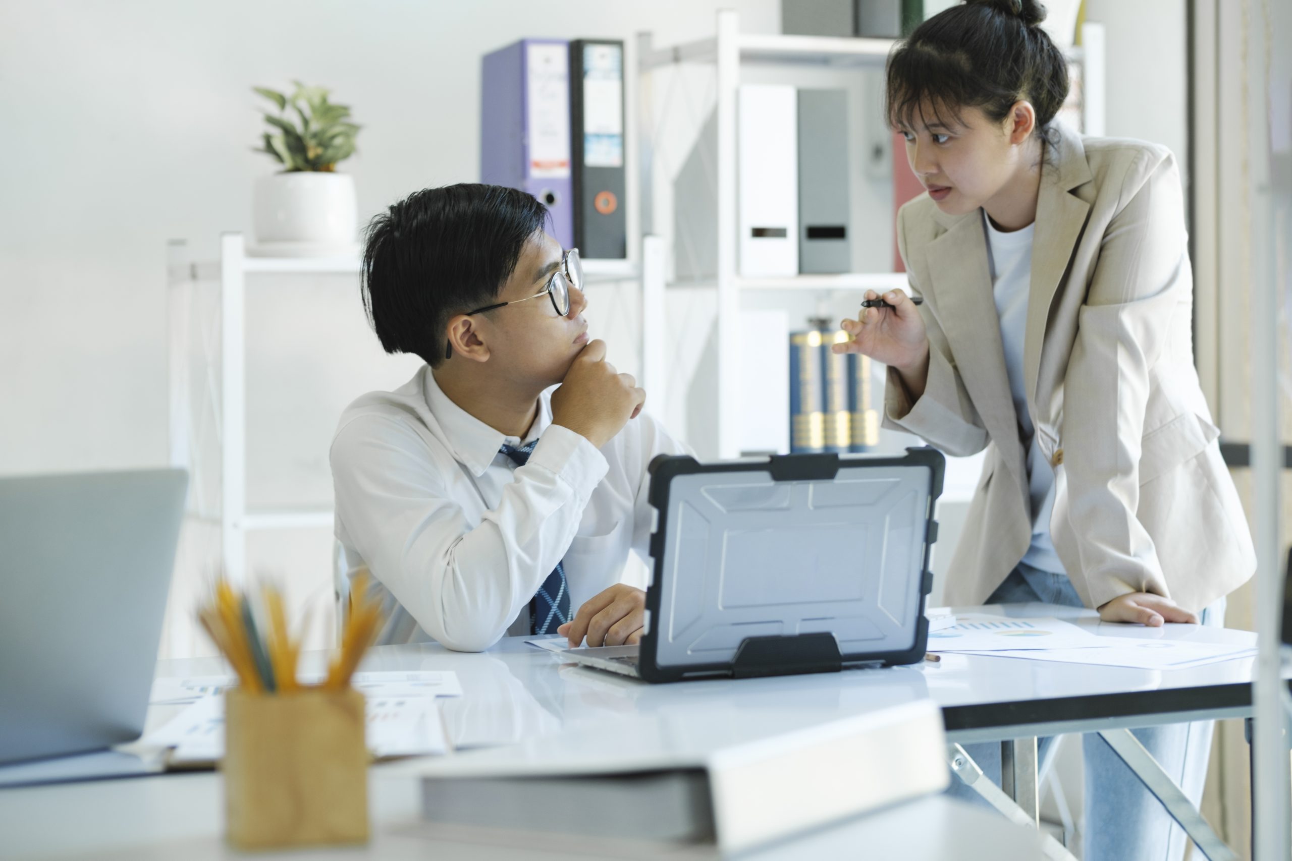 Businesspeople or colleagues are working together on investment project, discussing, sharing ideas, planning, and analyzing the business strategy and finance using laptop computer.